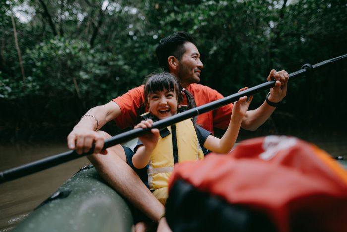 Japanese father and preschool daughter paddling a kayak together in mangrove swamp, Iriomote Ishigaki National Park of the Yaeyama Islands, Okinawa, Japan