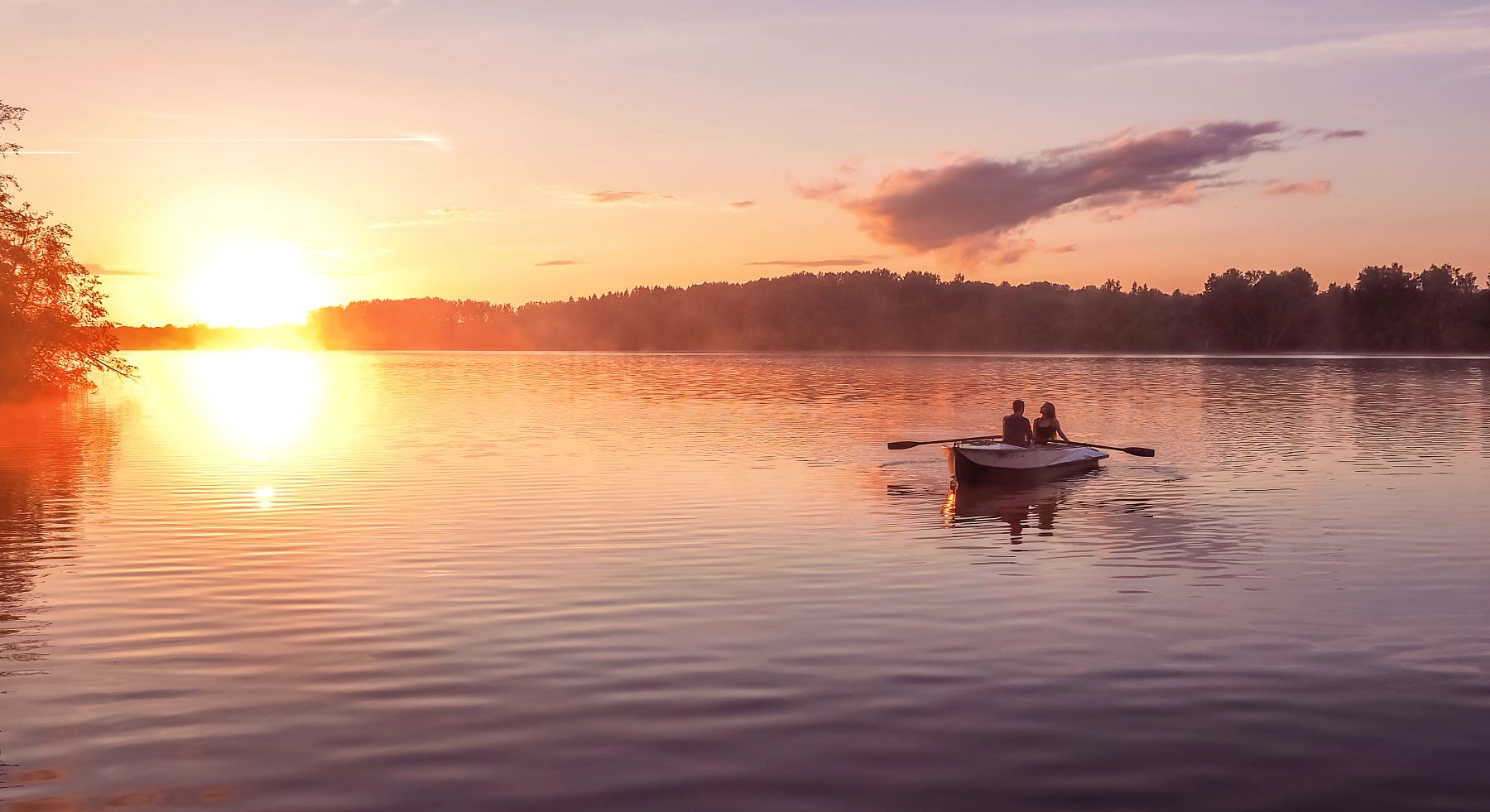 Romantic golden sunset river lake fog loving couple small rowing boat