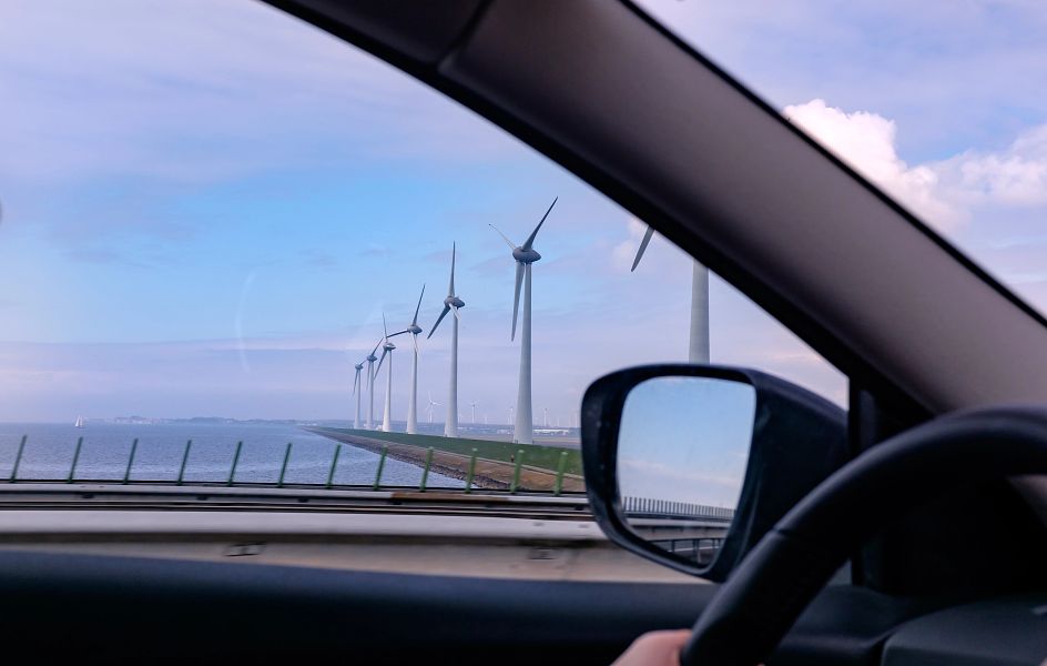 Wind turbine generating electricity on blue sky with clouds