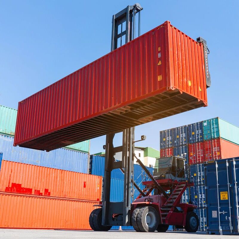 forklift working in the container cargo yard port loading cargo tank logistic service and transportation concept