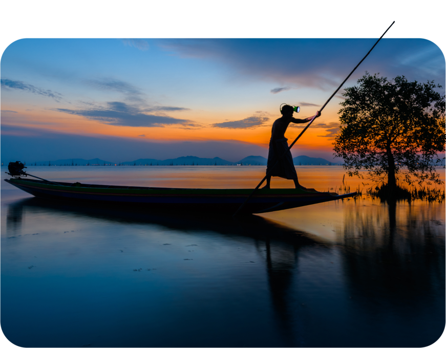 Man paddling a boat at dawn