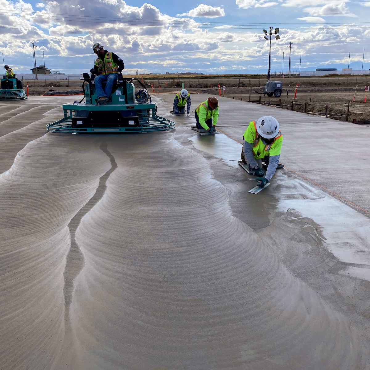 Workers smoothing out freshly poured cement