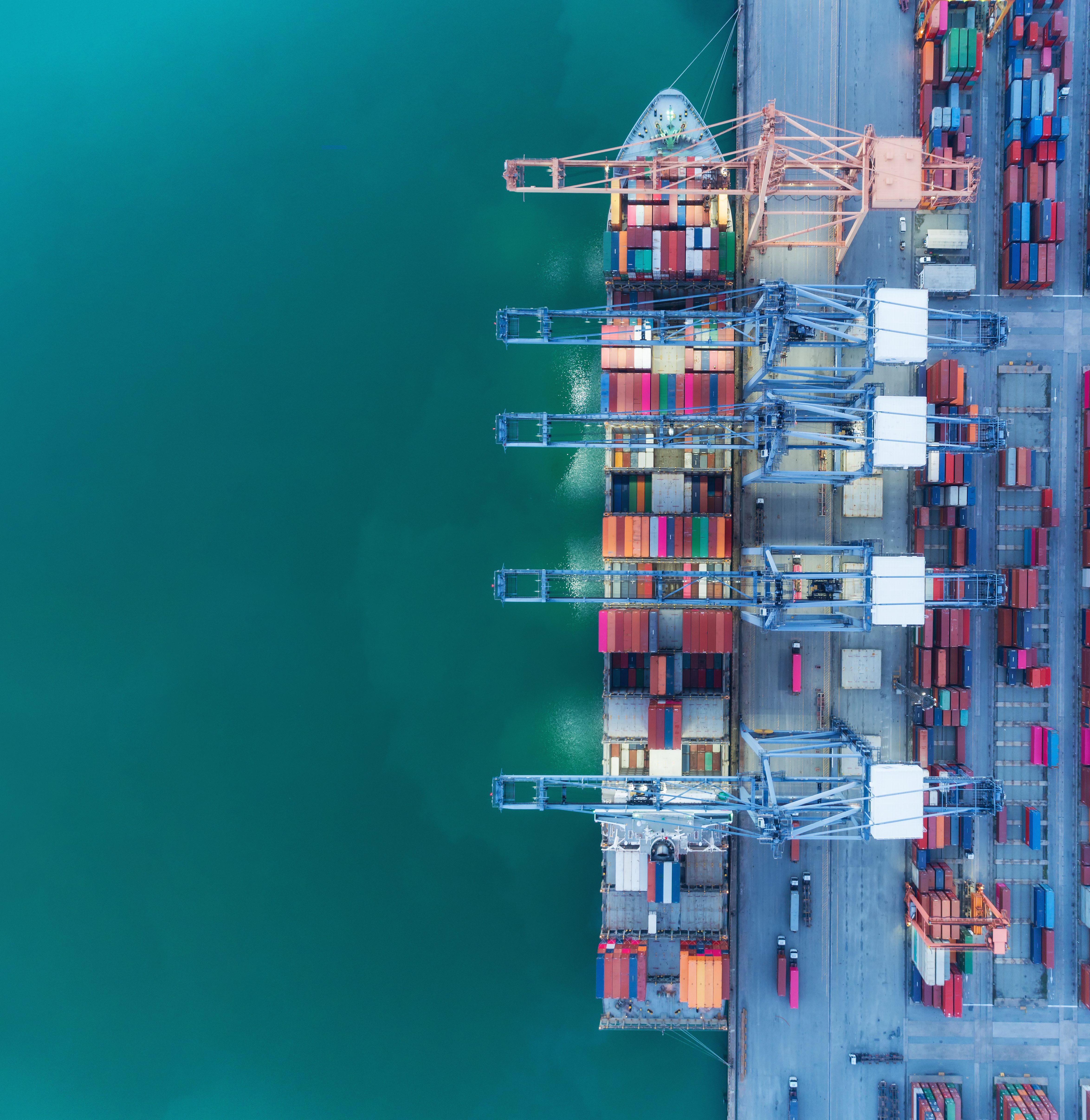 Aerial top view container ship at sea port and working crane bridge loading container for logistics import export, shipping or transportation.