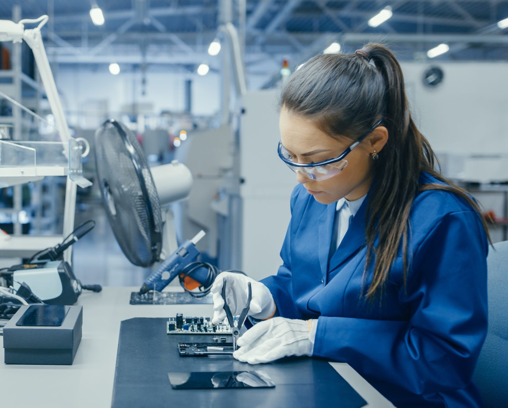 Young Female Blue and White Work Coat within a high tech facility