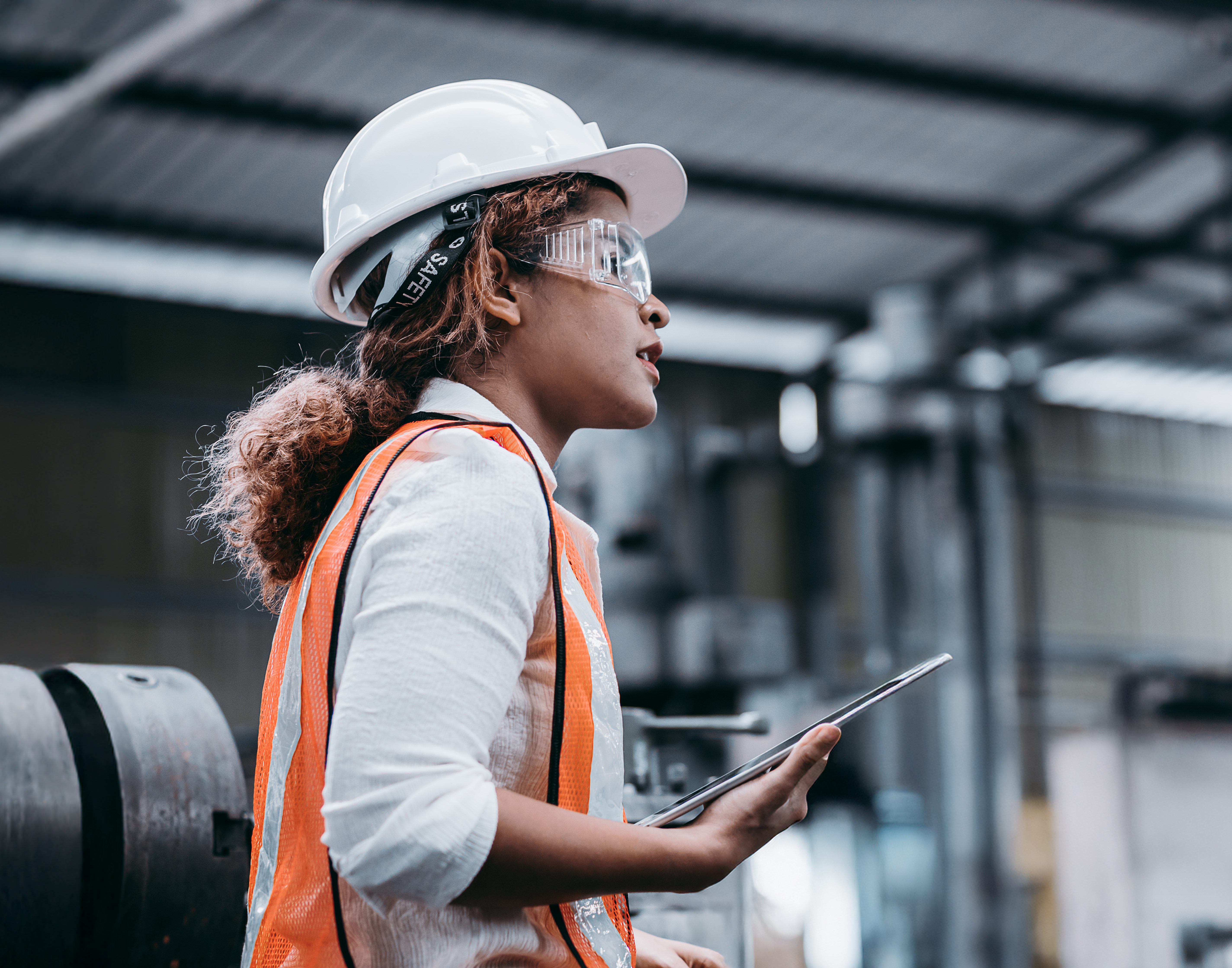 Woman factory worker with a hard gas and safety glasses on