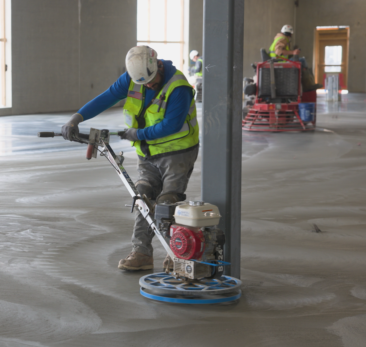 workers pouring and smoothing concrete