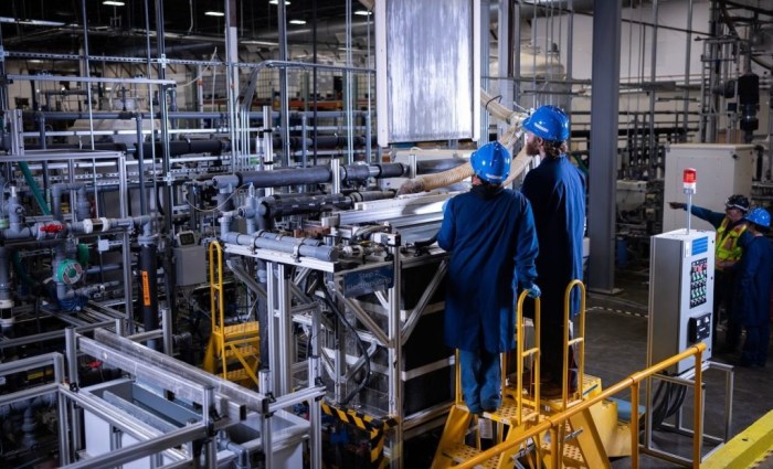 Two people standing in a factory.